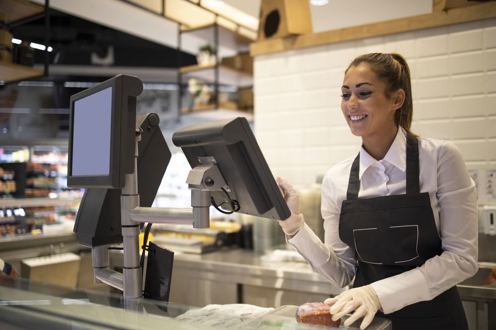 Une vendeuse sert un client au comptoir d'un magasin